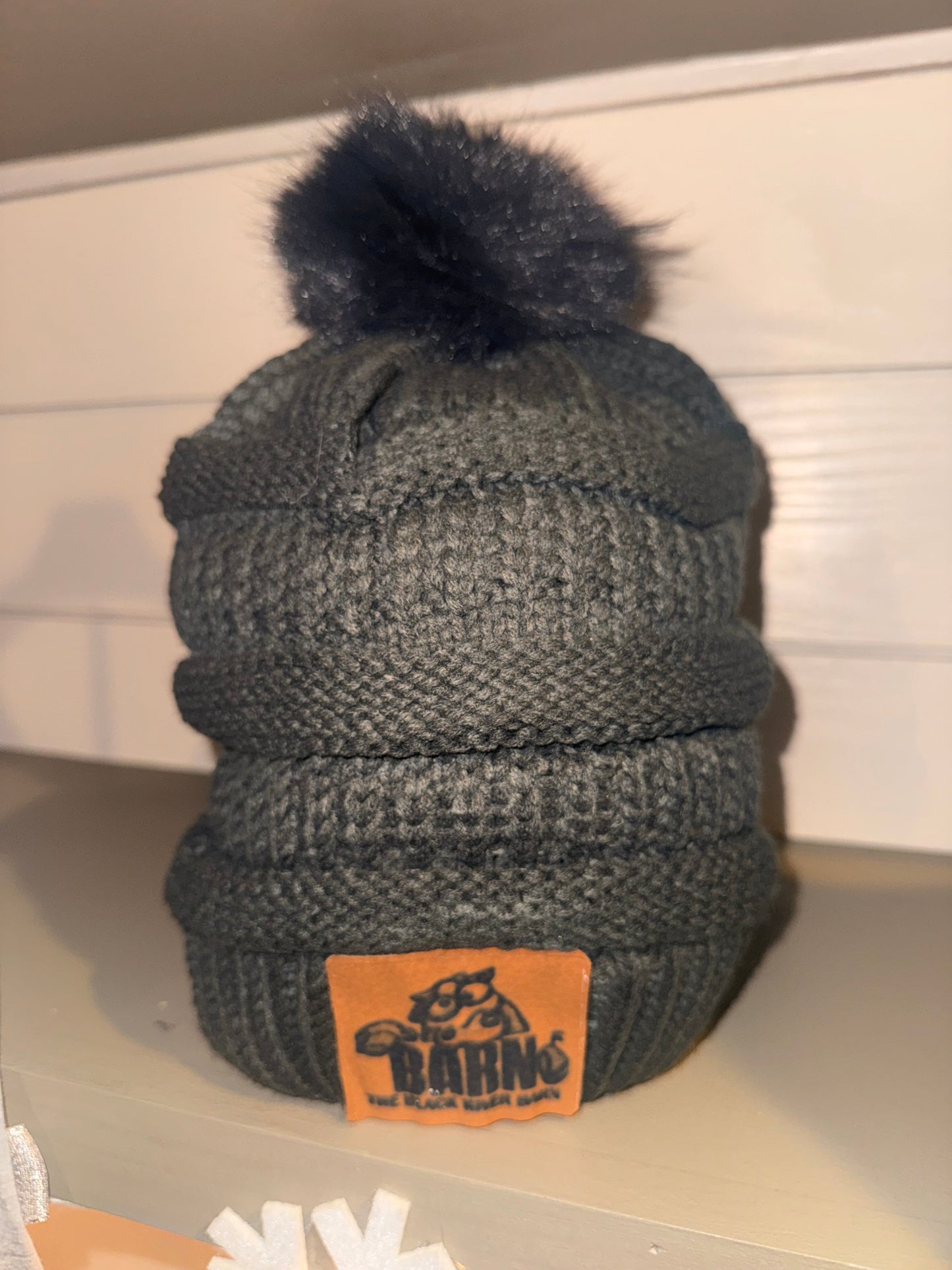 Gray knit Black River Barn pom beanie with logo patch and pom on top
